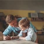 Vater und Sohn entwerfen in der Werkstatt gemeinsam ein Haus -Architekt Titelbild
