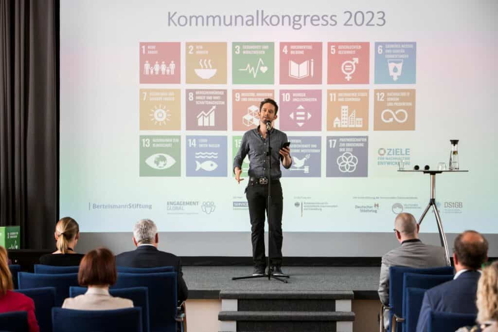 Poetry Slammer Zwergriese mit einem Text über Nachhaltigkeit beim Kommunalkongress Nachhaltigkeit aktiv gestalten im Juni 2023 in Potsdam